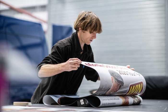 A staff member rolling out exhibition graphics