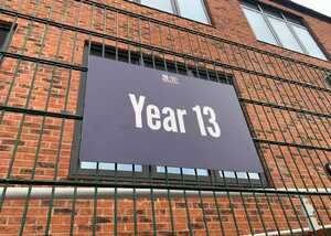 Sign on a metal fence that reads "Year 13."