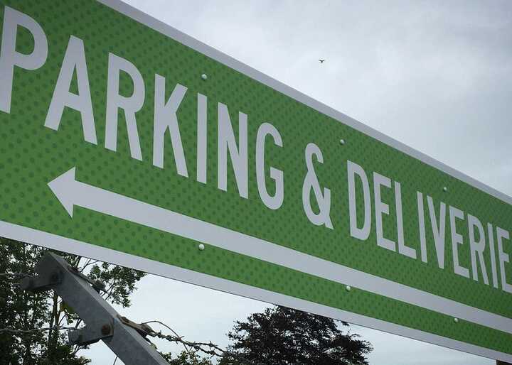 Green sign with white text reading "PARKING & DELIVERIES" and a left-pointing arrow.