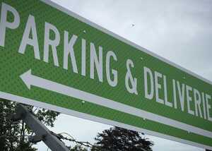 Green sign with white text reading "PARKING & DELIVERIES" and a left-pointing arrow.