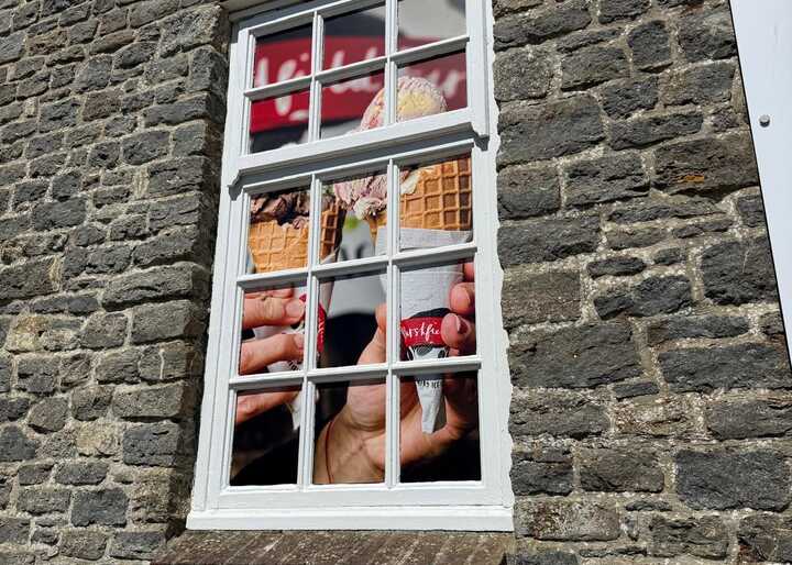 A window with a colorful advertisement behind it, set in a stone wall.