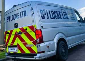 Expertly peeling back the vinyl backing sheet for a gloss finish vehicle graphic installation
