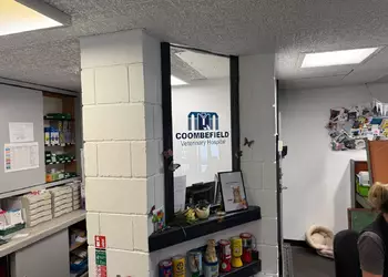 Interior of an office with a logo on a window and shelves with various items.