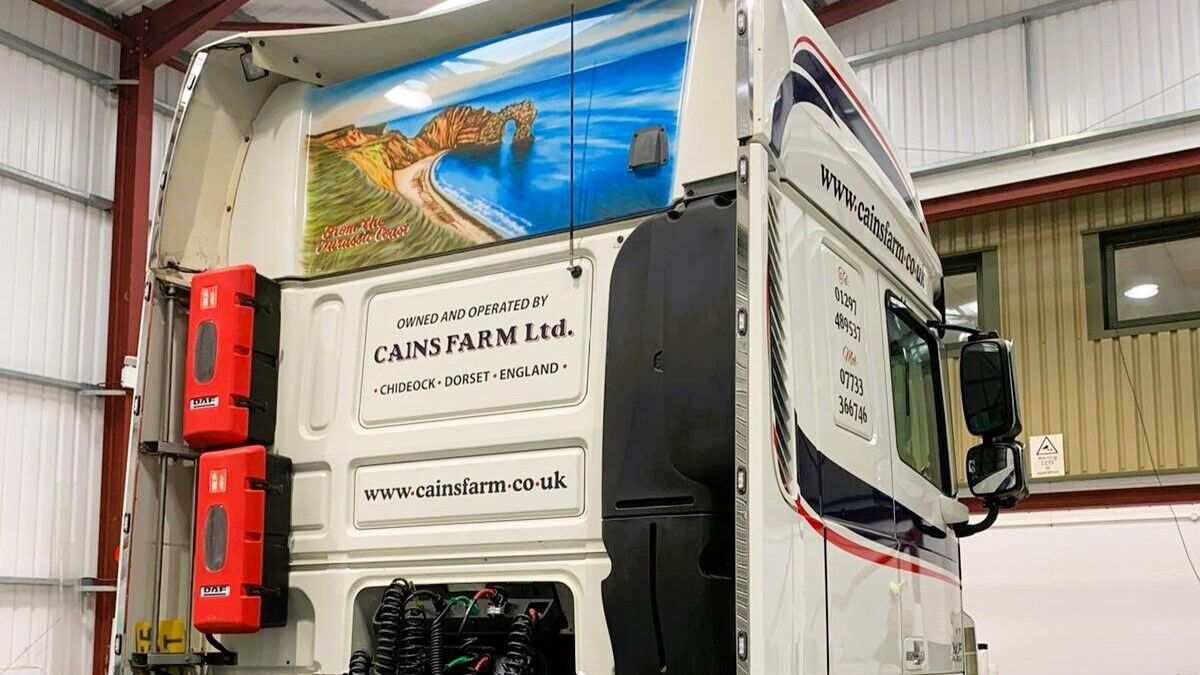 Cains Farm Transport Lorry Back View of Lorry Cab Printed Durdle Door Scene and Cab Branding Graphics.jpg