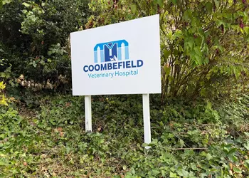 Sign for Coombefield Veterinary Hospital surrounded by greenery.