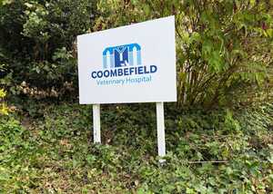 Sign for Coombefield Veterinary Hospital surrounded by greenery.