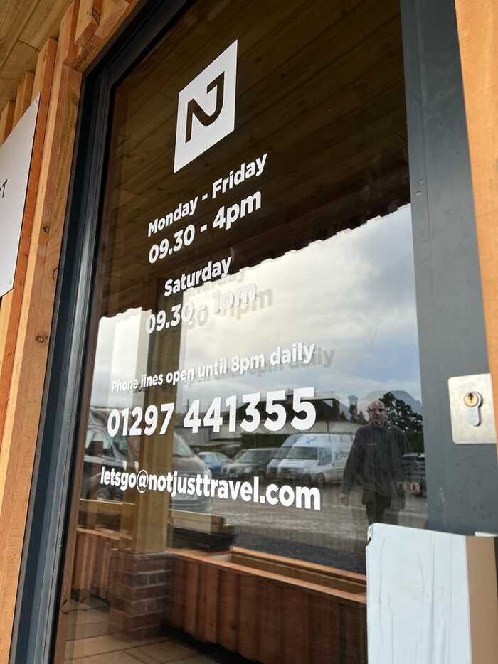Glass Window Graphics Displaying Contact & Opening Information for Not Just Travel