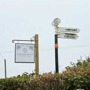 Hanging Projecting Roadsign visible over the hedge for Furleigh Estate