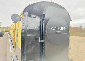 Side view of a train car with a sign reading "PLATFORM EST 2011."