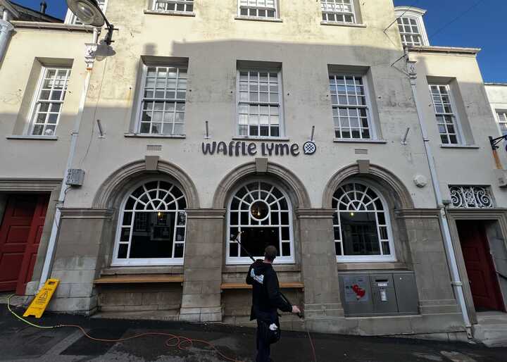 Exterior of a building with large arched windows and the name "Wanted Youth" above the entrance.