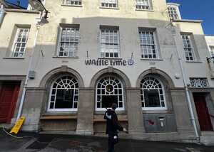 Exterior of a building with large arched windows and the name "Wanted Youth" above the entrance.