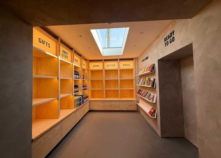A well-lit room with empty wooden shelves and a skylight above.