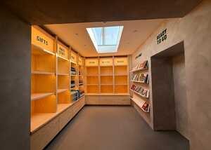 A well-lit room with empty wooden shelves and a skylight above.