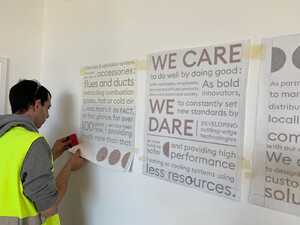 Installing new wall display - cut vinyl typography print for business