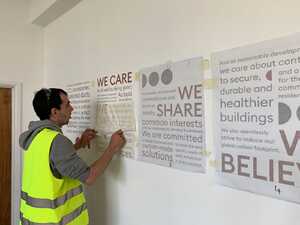 Installing new wall display - cut vinyl typography print for business