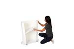 Lady adding the storage shelf to the Finesse2 promotional display counter.jpg