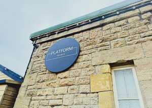 Sign on a stone wall reads "PLATFORM EST 2015" with a round black background.