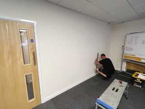 Measuring wall space ready for magnetic whiteboard wall installation