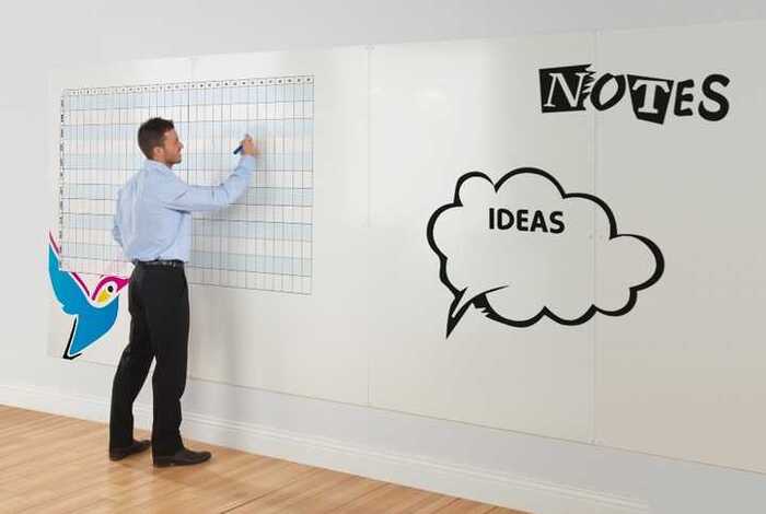 Man writing on whiteboard wall Man writing on whiteboard wall