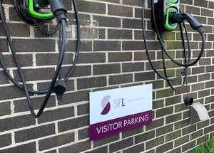 Business Parking Signs Mounted Near New Electrical Car Charging Ports