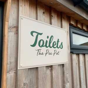 Directional Signage For The Toliets At Millers Farm Shop - ACM Panel Mounted To Wooden Slat Wall