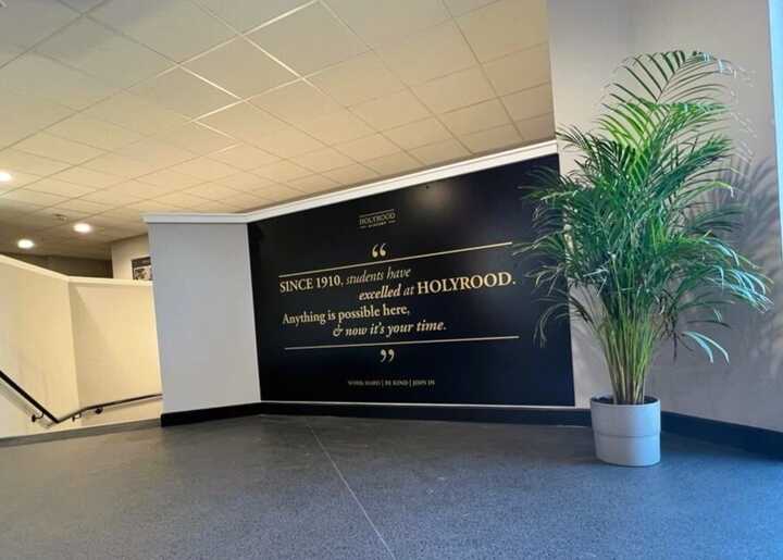 Black ACM Display Panel With Gold Vinyl Text Applied At Top Of School Staircase - Holyrood Academy