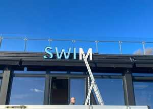 Old SWIM Illuminated Lettering Signage Being Removed Old SWIM Illuminated Lettering Signage Being Removed