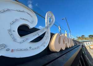 SWIM Illuminated Lettering Signage Mounted Above Restaurant Entrance