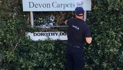 Signage being installed at Devon Carpets